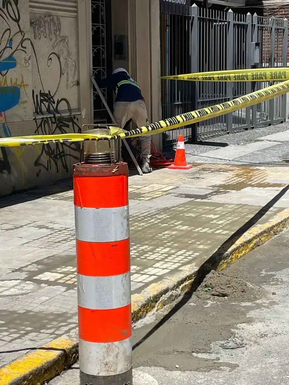 Zona de obra delimitada con cinta de seguridad en el acceso al edificio